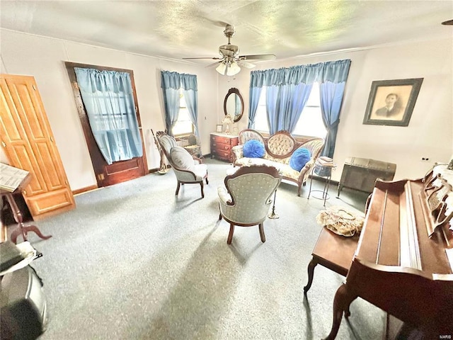 living area featuring plenty of natural light, ceiling fan, a textured ceiling, and carpet