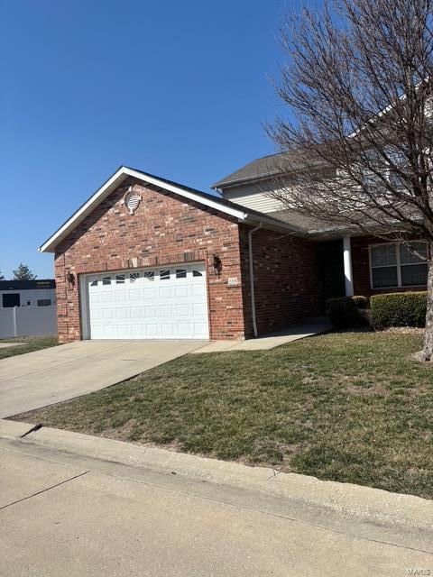 ranch-style home featuring a garage, driveway, brick siding, and a front lawn