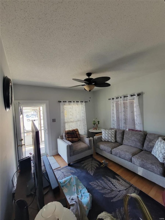 living area featuring a textured ceiling, wood finished floors, and a ceiling fan