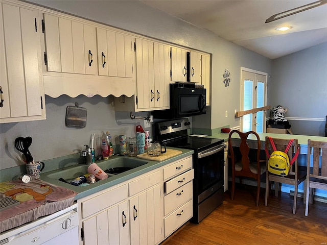 kitchen featuring a sink, wood finished floors, stainless steel range with electric cooktop, white dishwasher, and black microwave