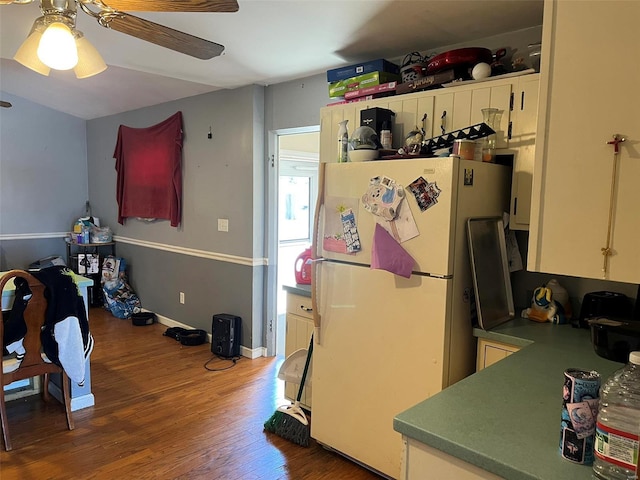 kitchen with ceiling fan, wood finished floors, white cabinets, and freestanding refrigerator