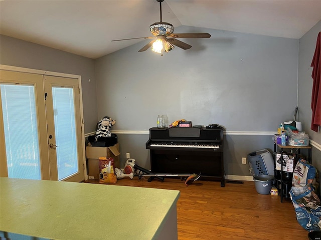 interior space with wood finished floors, baseboards, ceiling fan, vaulted ceiling, and french doors