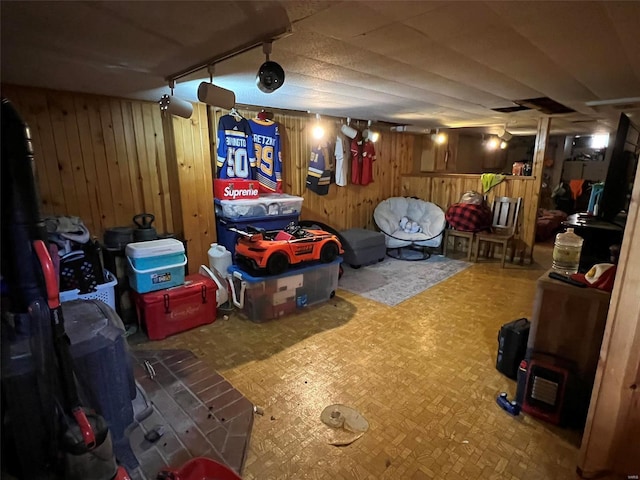 finished basement featuring track lighting and wood walls