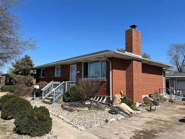 single story home with brick siding and a chimney