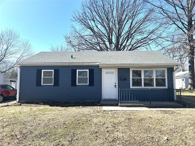 view of front of property with a front lawn and a shingled roof