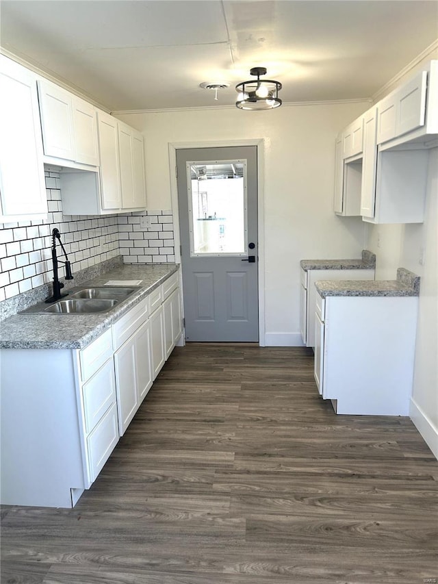 kitchen with dark wood-type flooring, white cabinets, and a sink