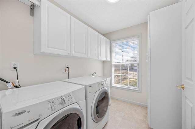 laundry area with baseboards, washing machine and dryer, light tile patterned floors, cabinet space, and a textured ceiling