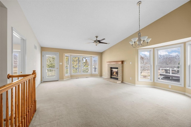 unfurnished living room featuring baseboards, high vaulted ceiling, a fireplace, carpet flooring, and ceiling fan with notable chandelier