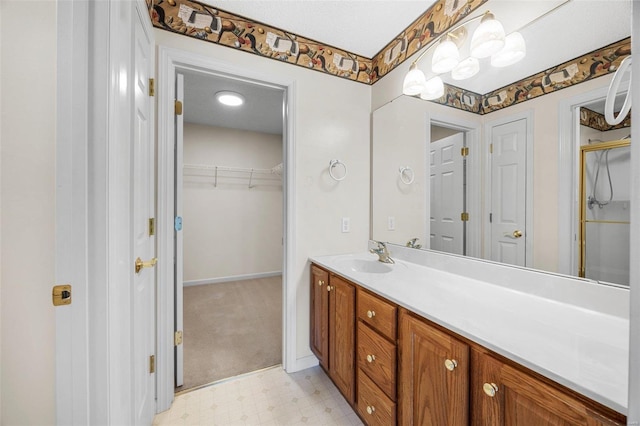 full bath featuring tile patterned floors, an enclosed shower, vanity, baseboards, and a spacious closet