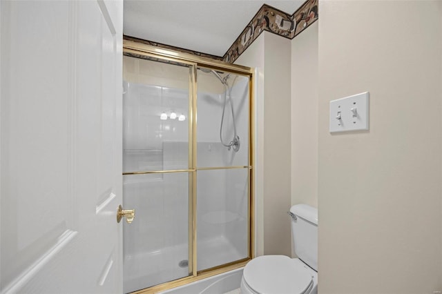 full bathroom with a shower stall and toilet