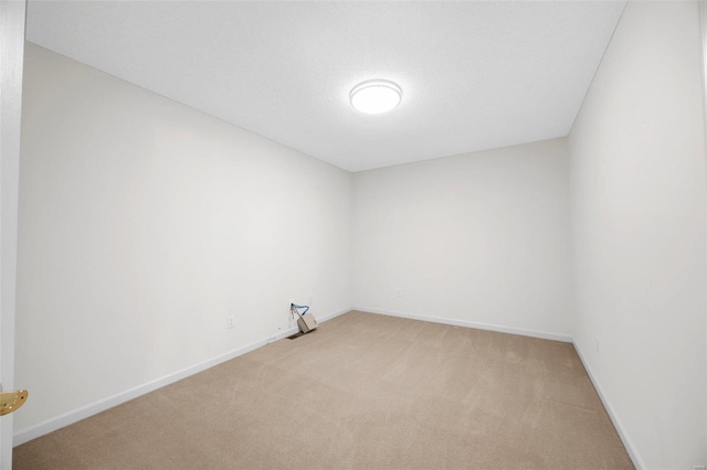 unfurnished room featuring baseboards, light colored carpet, and a textured ceiling