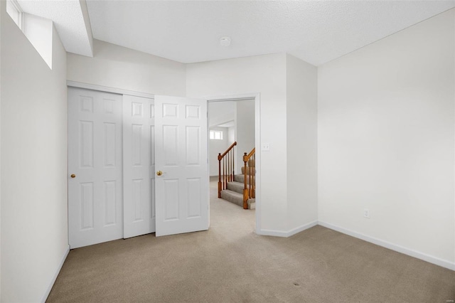 unfurnished bedroom with a closet, baseboards, and carpet