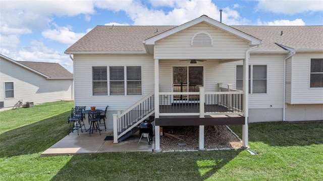 back of property featuring a lawn, a ceiling fan, a patio, roof with shingles, and a wooden deck