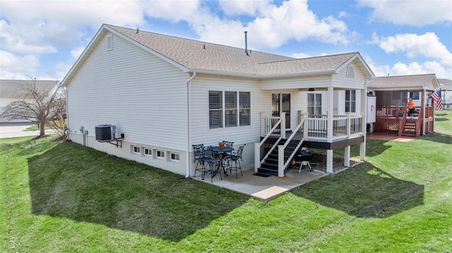 rear view of property featuring a patio, a yard, stairway, roof with shingles, and a wooden deck