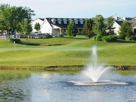 surrounding community featuring view of golf course, a yard, and a water view