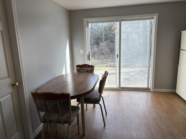 dining space with baseboards and wood finished floors