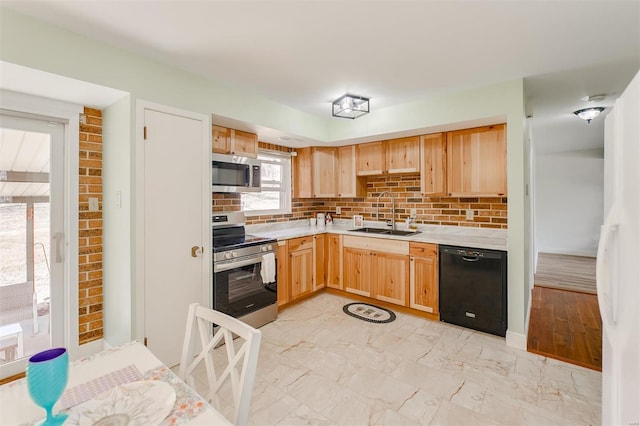 kitchen with light brown cabinetry, light countertops, marble finish floor, stainless steel appliances, and a sink