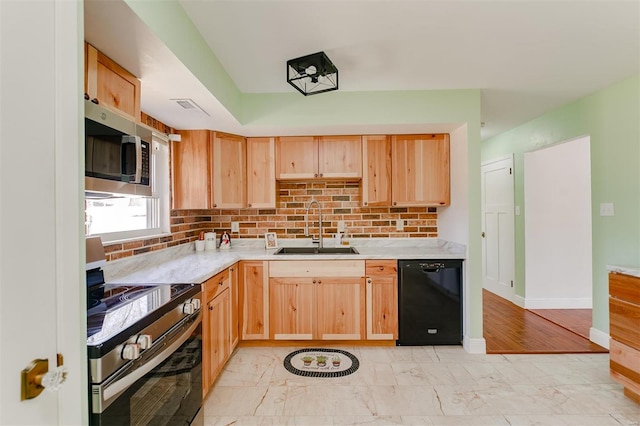 kitchen with a sink, light countertops, light brown cabinets, and stainless steel appliances