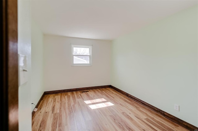 spare room featuring visible vents, baseboards, and light wood finished floors