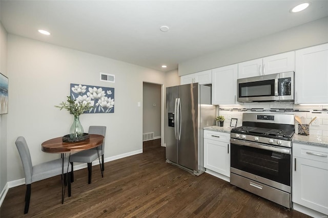 kitchen featuring dark wood finished floors, visible vents, stainless steel appliances, and decorative backsplash