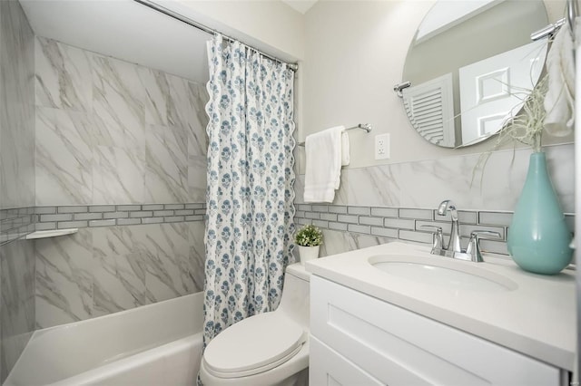 full bath with vanity, toilet, tile walls, and shower / bath combo