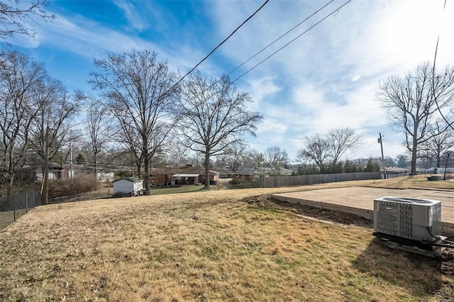 view of yard with central AC unit and fence