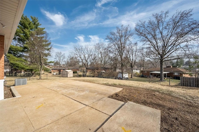 view of yard featuring fence, an outbuilding, and a shed