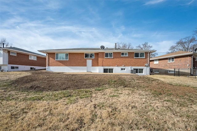 rear view of house with brick siding and a yard