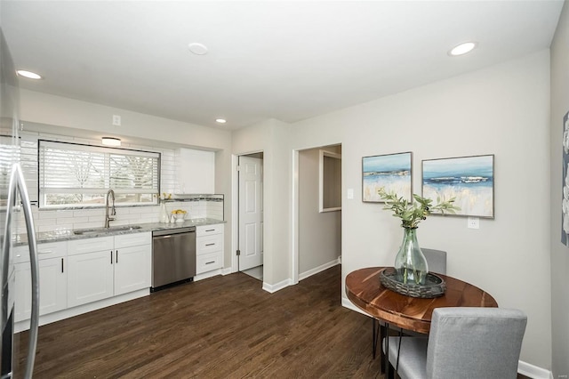 kitchen with dishwasher, light stone counters, dark wood-style floors, white cabinetry, and a sink