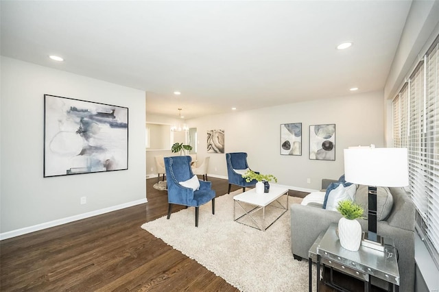 living room featuring recessed lighting, baseboards, a notable chandelier, and wood finished floors