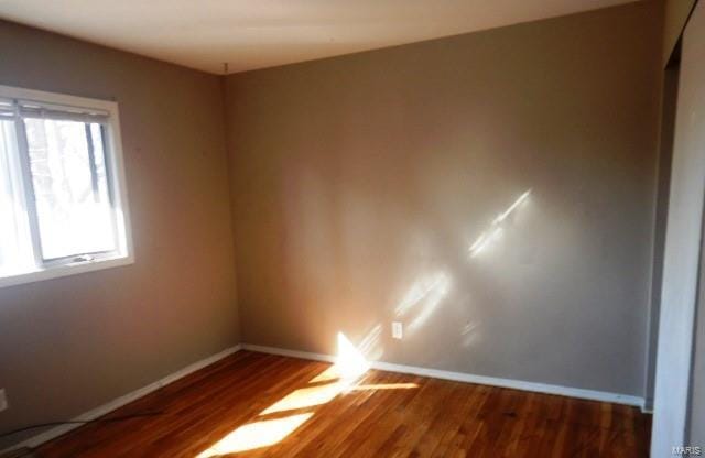 spare room with wood finished floors and baseboards