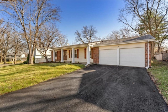 single story home featuring brick siding, a front lawn, fence, a garage, and driveway