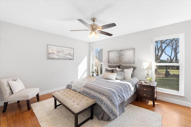 bedroom with ceiling fan, baseboards, and wood finished floors