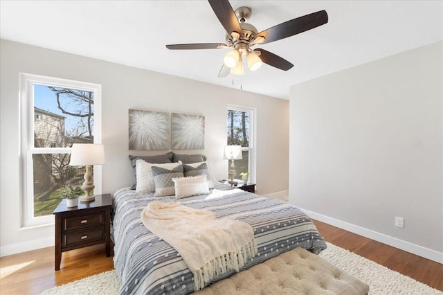 bedroom featuring ceiling fan, baseboards, and wood finished floors