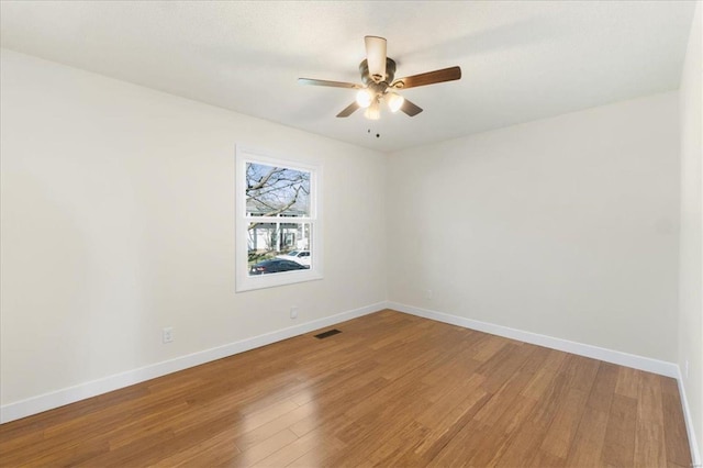 unfurnished room featuring visible vents, light wood-style flooring, baseboards, and ceiling fan