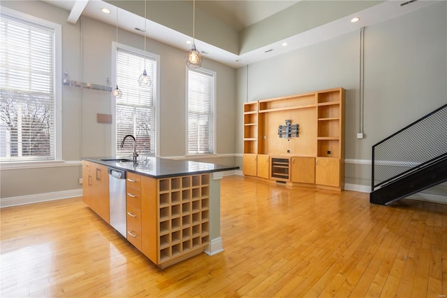 kitchen with beverage cooler, light wood-style flooring, a sink, dishwasher, and dark countertops