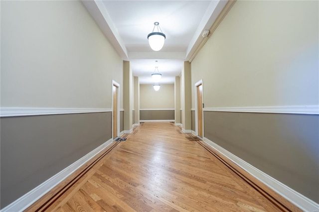 hall with baseboards and wood finished floors