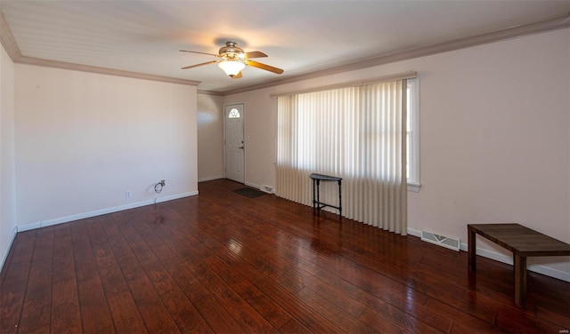 empty room with visible vents, crown molding, baseboards, and hardwood / wood-style flooring