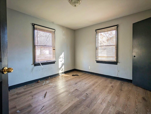 unfurnished room with baseboards and wood finished floors