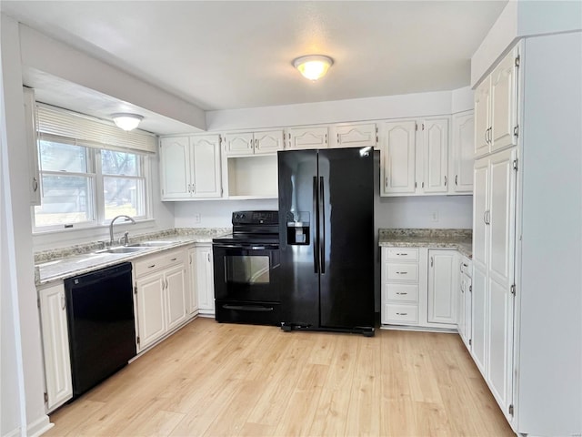 kitchen featuring open shelves, a sink, black appliances, white cabinets, and light wood-style floors