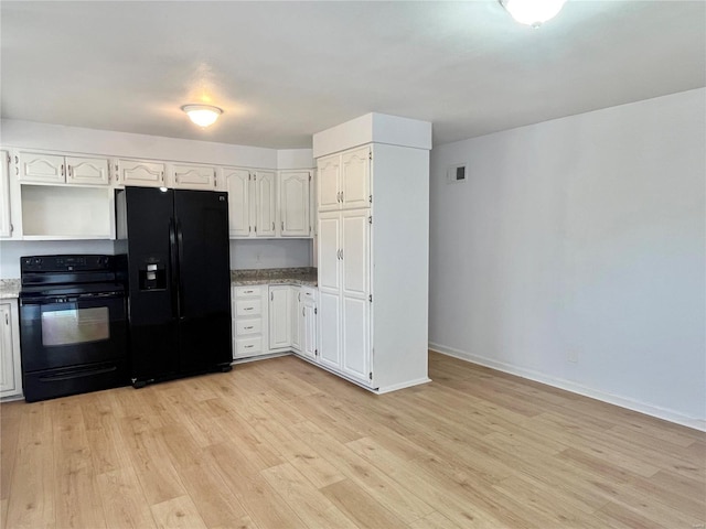 kitchen with baseboards, visible vents, light wood finished floors, black appliances, and white cabinets