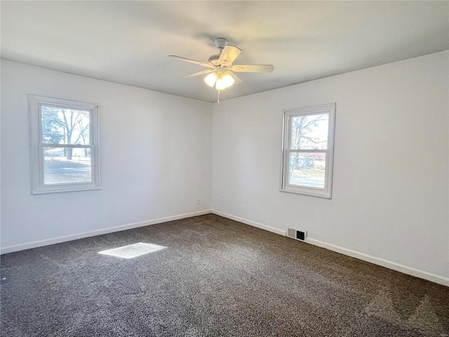 carpeted empty room with baseboards, visible vents, and ceiling fan