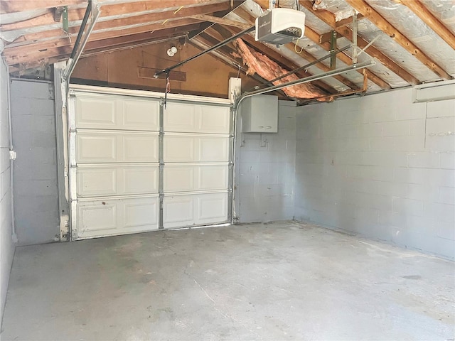 garage with concrete block wall and a garage door opener