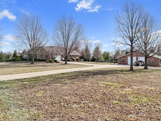 view of yard featuring an attached garage and driveway