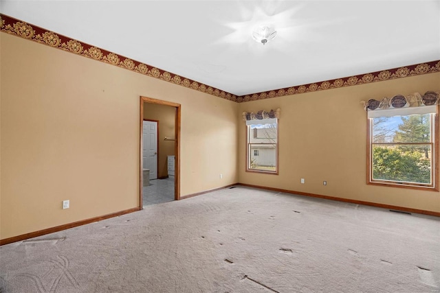 carpeted empty room with visible vents and baseboards