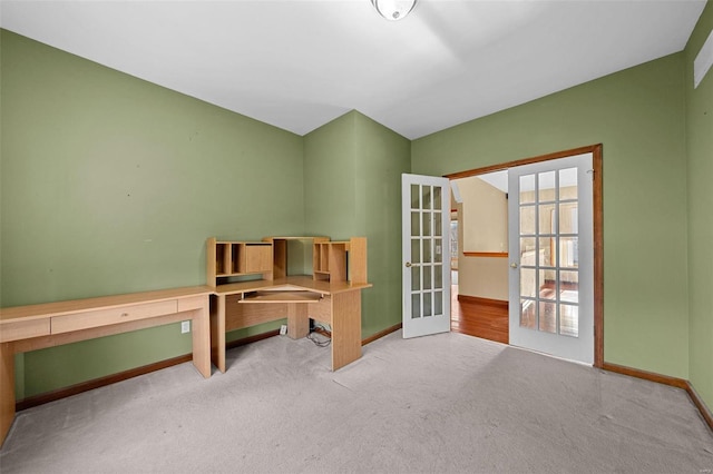 carpeted office space featuring french doors and baseboards