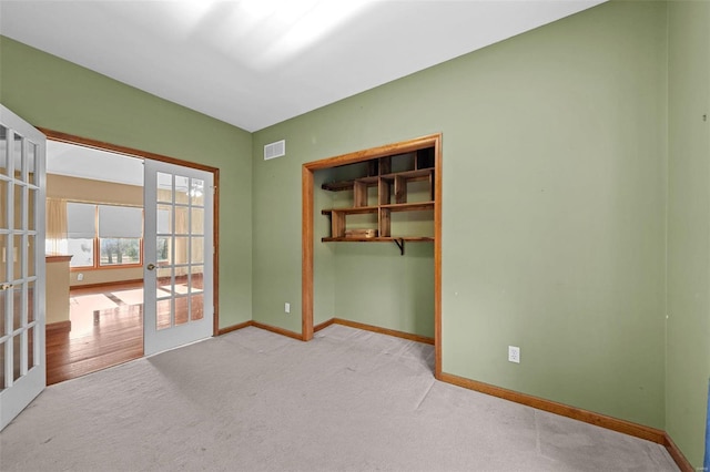 unfurnished room with french doors, baseboards, carpet floors, and visible vents