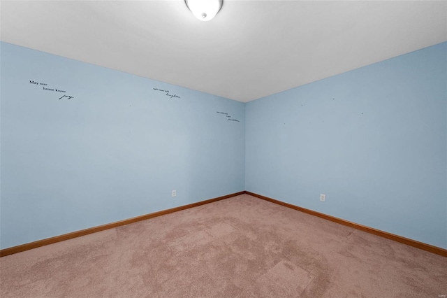 unfurnished room with baseboards and light colored carpet