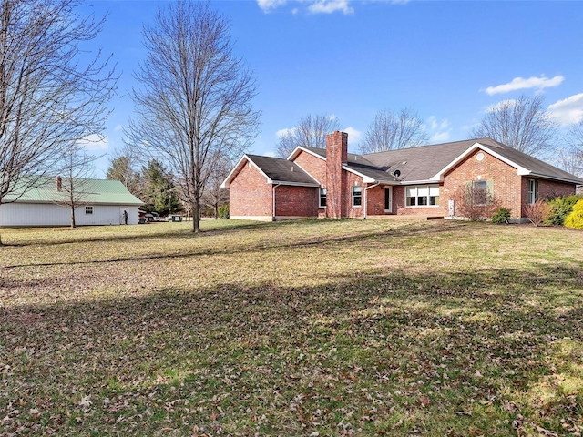 exterior space with brick siding, a lawn, and a chimney