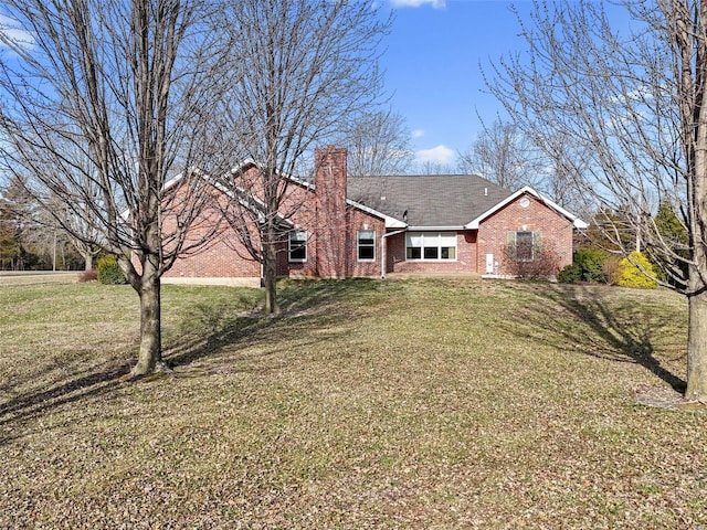 rear view of property featuring a lawn, brick siding, and a chimney